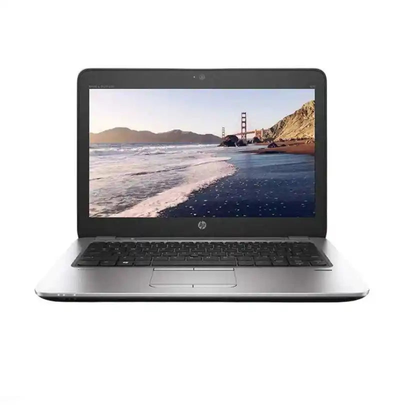 Laptop displaying a scenic image of a beach and bridge on a white background