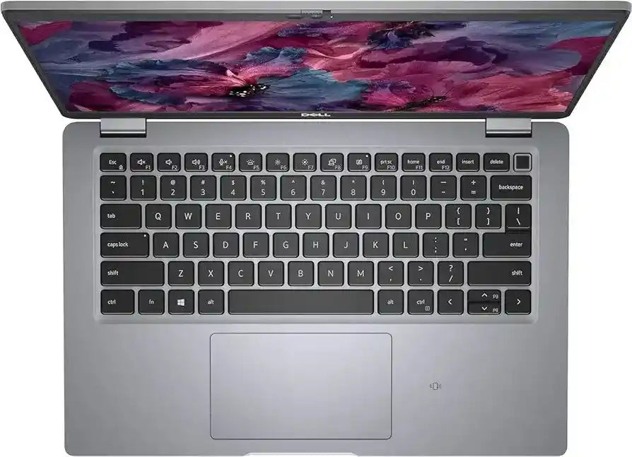 A silver Dell laptop shown from a top-down angle with the screen open, featuring a black keyboard and a colorful abstract floral wallpaper on the display.