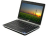 A Dell laptop shown open at an angle on a plain white background, with the screen displaying a sunset landscape over a field of wind turbines.