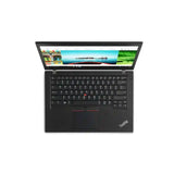 A black Lenovo ThinkPad laptop shown open from a top-down view on a plain white background. The screen is on and displays a colorful webpage, while the keyboard, trackpad, and red TrackPoint nub are clearly visible.